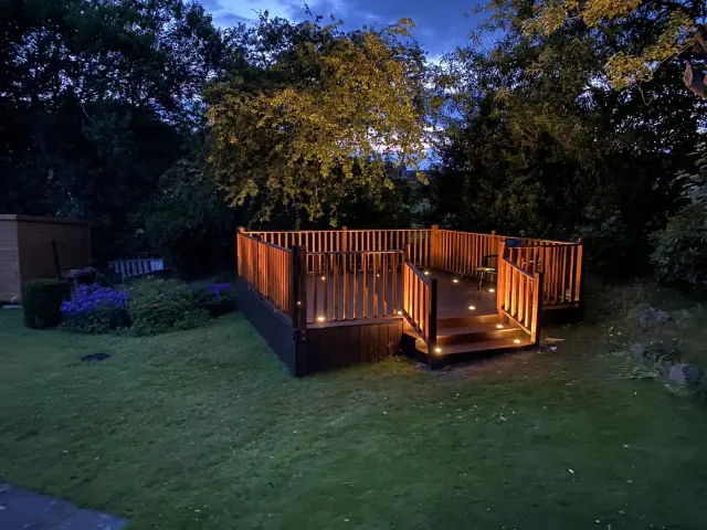 Wooden deck with warm lights at night.